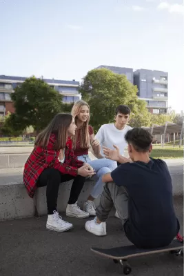 Cuatro adolescentes hablando en un parque